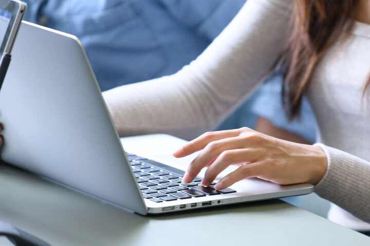 Hände einer Person, die am Laptop schreibt